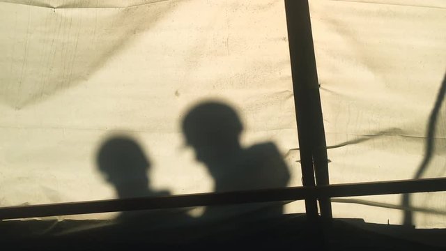 Construction Worker Silhouettes From Behind Paper Screen