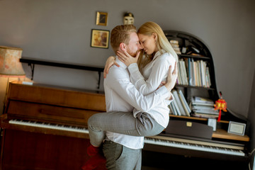 Loving young couple kissing in the room