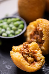 Arancini rice and meat dish on black