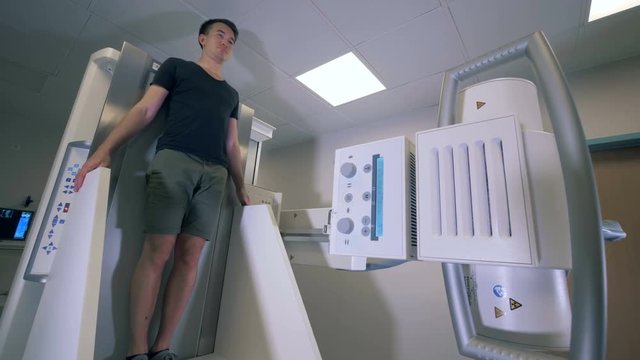 A person using vertical tomography machine, close up.