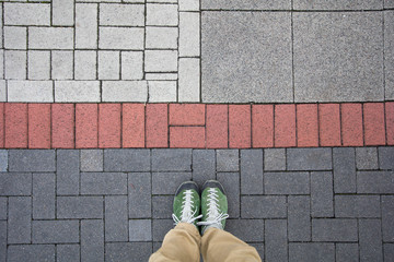 Top view of a man standing on the colorful geometrical pavement