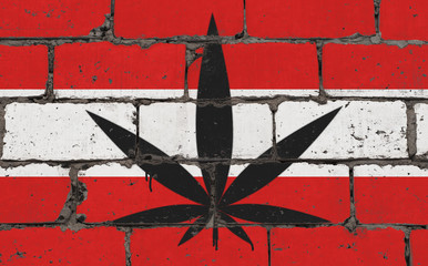 Graffiti street art spray drawing on stencil. Cannabis leaf on brick wall with flag Austria.