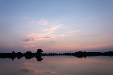 Pink clouds over a calm lake after sunset