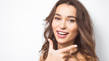 Portrait of a young smiling woman with beautiful white teeth. Girl demonstrates smooth healthy teeth on a white background. 