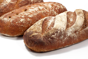 Bread - raye sourdough bread, several loaves nearby. Diagonal composition.