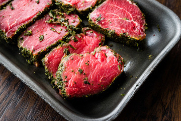 Package of Raw Tenderloin Meat with Herbs and Spices in Plastic Box / Container.