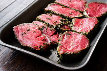 Package of Raw Tenderloin Meat with Herbs and Spices in Plastic Box / Container.