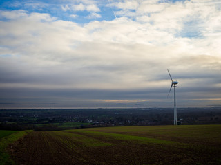 Fototapeta na wymiar Alternative energy source. Rural landscape farm with a single windmill turbine near Cardiff, Wales UK
