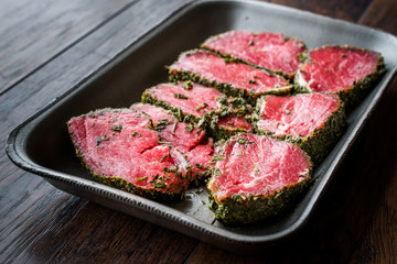 Package of Raw Tenderloin Meat with Herbs and Spices in Plastic Box / Container.