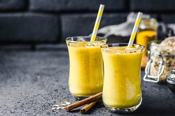 Cinnamon ginger turmeric smoothie on dark background. Selective focus, space for text.