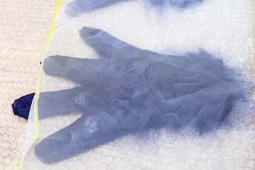 wet glove with new fibers under plastic mesh