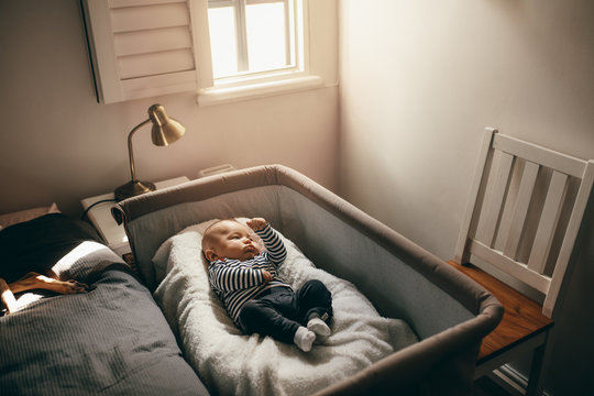 Baby sleeping in a bedside crib