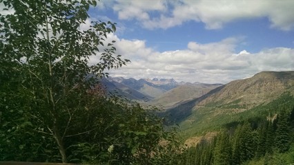 Glacier National Park mountains and forest on a clear day with some clouds. Beautiful