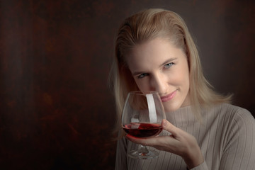 Portrait of a beautiful woman with glass of brandy.