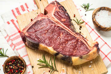 T-bone beef steak on white with spices. 