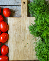 vegetables on the kitchen board - tomatoes, herbs, dill, carrots. copy space. top