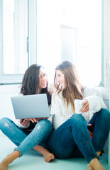 Two attractive woman with laptop at home