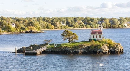 Lighthouse on a lonely island in the bay near the coast. © momentscatcher