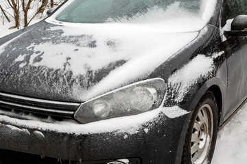 Black dirty car under the snow. Frozen car. winter problems to start engine