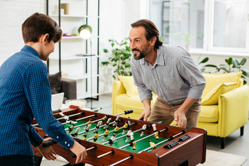 Emotional man playing table football with his son