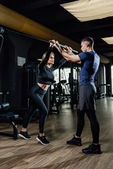  gym personal trainer man with weight lifting bar woman workout in fitness exercise © Alexandr