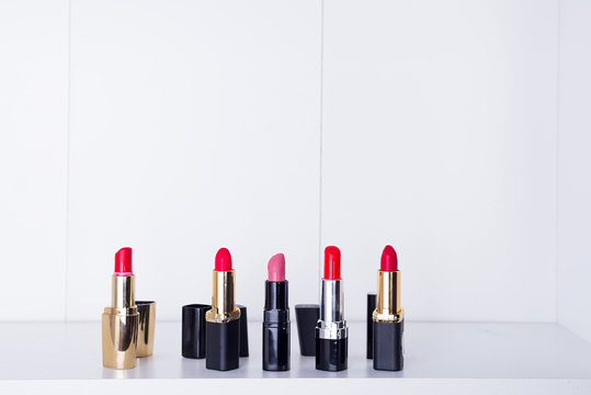 a set of several used red lipsticks on a shelf in the bathroom, copy space