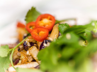 Red hot chilli pepper over green east asian salad