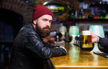 Bar is relaxing place to have drink and relax. Man with beard spend leisure in dark bar. Brutal lonely hipster. Hipster relaxing at bar. Brutal hipster bearded man sit at bar counter. Friday evening