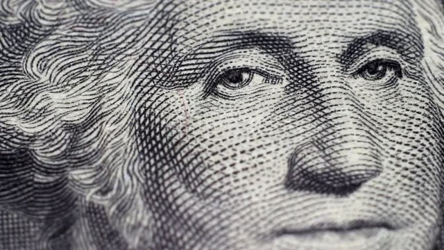 Tracking macro of George Washington's face on the US one dollar bill.
