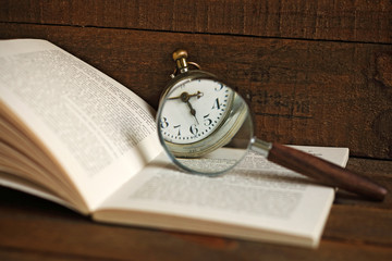 Pocket clock, book and magnifying glass