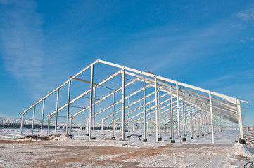 The structure of the building. Steel construction on the background of the winter landscape.