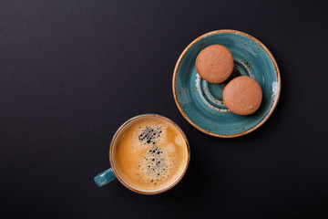 Blue cup of coffee and macaroons on the dark wooden table. Coffe break. Top view. Flat lay