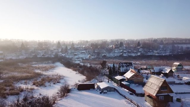 4k aerial photography. Winter landscape on the village. Warm sunset light.