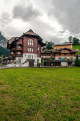 Fototapeta na wymiar Mountains in Switzerland with wooden houses on a cloudy day