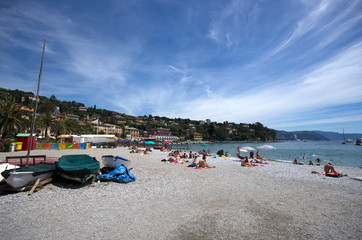 Fototapeta na wymiar Rapallo / Italy - June 20 / 2016 : People resting at the beach of Rapallo