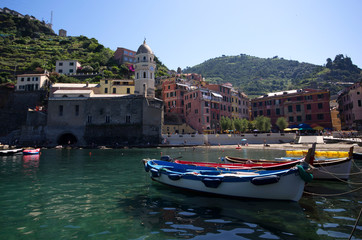 Fototapeta premium Vernazza, Liguria / Italy - June 23 / 2016: Boats and the clock tower at Vernazza