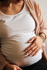 schwangere Frau mit Hand auf dem Bauch 1