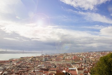 Sunny day in Lisbon. Panoramic view of the red roofs and blue sky with colorful light effects