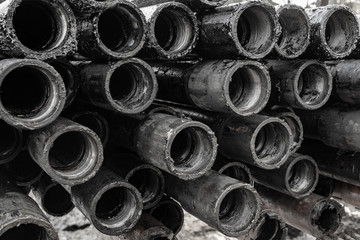 Oil Drill pipe. Rusty drill pipes were drilled in the well section.   View of the shell of drill pipes laid in courtyard of the oil and gas warehouse. Black and white photo