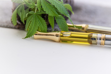 THC/CBD Cannabis Oil & Terpenes Filled Cartridges Up Close With Marijuana Plant Leafs