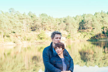 Two attractive dreamy people, couple in casual outfit at wild forest near water. Idyllic calm peaceful life style person freedom concept. Selective focus, copy space.