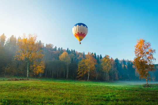 Colorful Hot Air Balloon Over The Green Field. Outdoor Activity Over National Park. Traveling Concept.