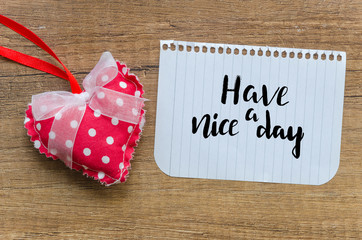 have a nice day message with handmade red heart on wooden background. Top view