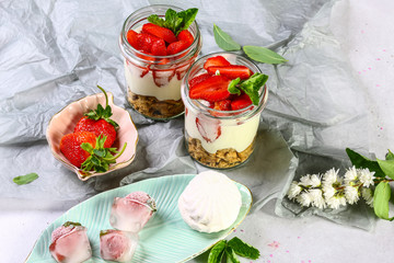 Dessert with fresh strawberries with whipped cream and mint on a rustic wood background