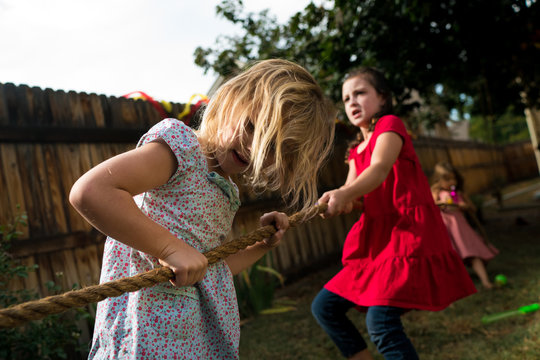 Friends playing tug of war in backyard