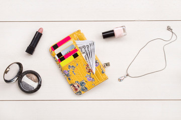 Woman wallet, cosmetics and accessories on gray background.