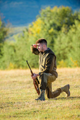 Hunter with rifle looking for animal. Hunting as male hobby and leisure. Man charging hunting rifle. Hunter khaki clothes ready to hunt hold gun mountains background. Hunting shooting trophy