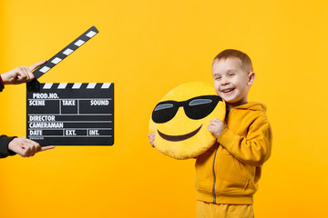 Little kid boy 3-4 years old in yellow clothes isolated on orange wall background, children studio...