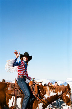Portrait of cowgirl riding horse against clear sky