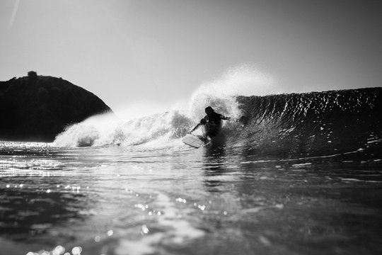 Surfer surfing in sea against sky